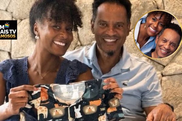 Maju Coutinho, jornalista da Globo, ao lado do marido, segurando uma roupinha de bebê, anuncia que está grávida.